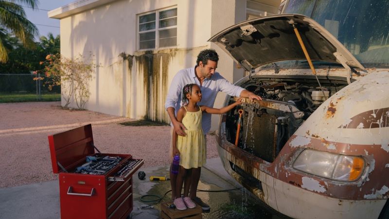 A weathered Class C with a leak in a Miami driveway.